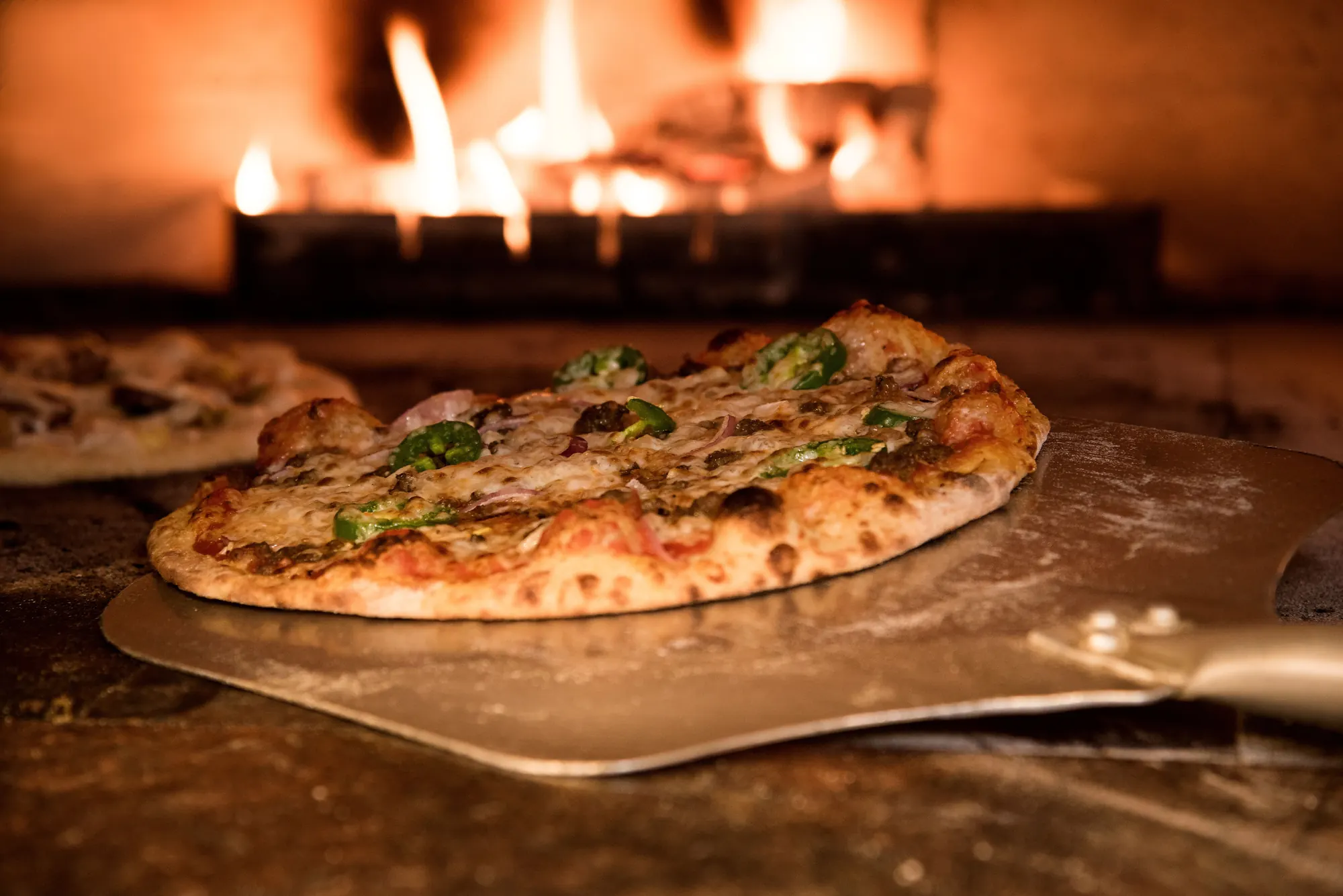 A wood-fired pizza on a peel